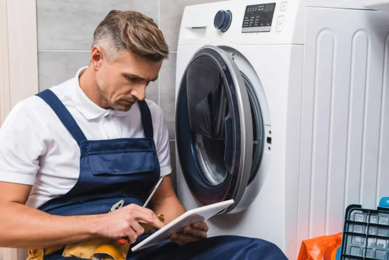 Technician fixing washing machine in Abu Dhabi home